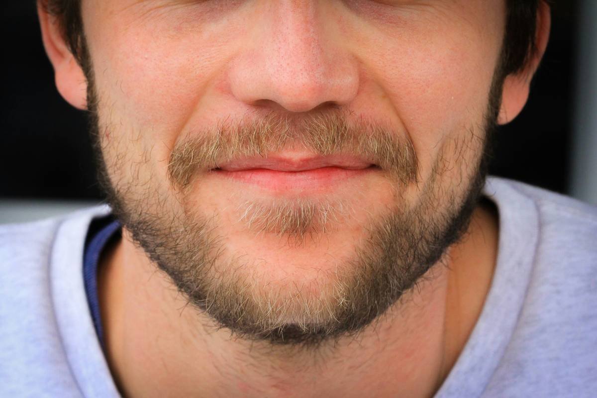 Side-by-side comparison of coarse boar bristle vs soft horsehair beard brushes on sensitive skin model