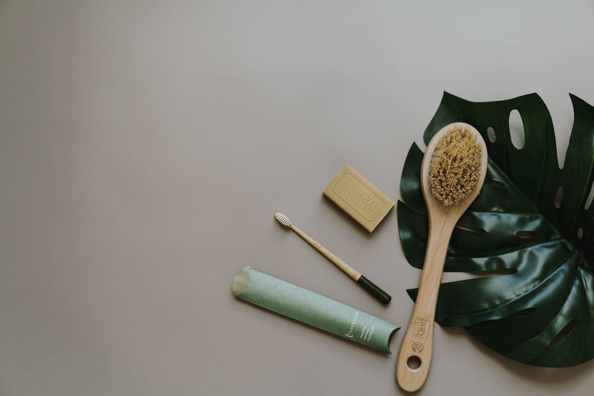 High-quality beard brush with wooden base held in hand against clean bathroom backdrop