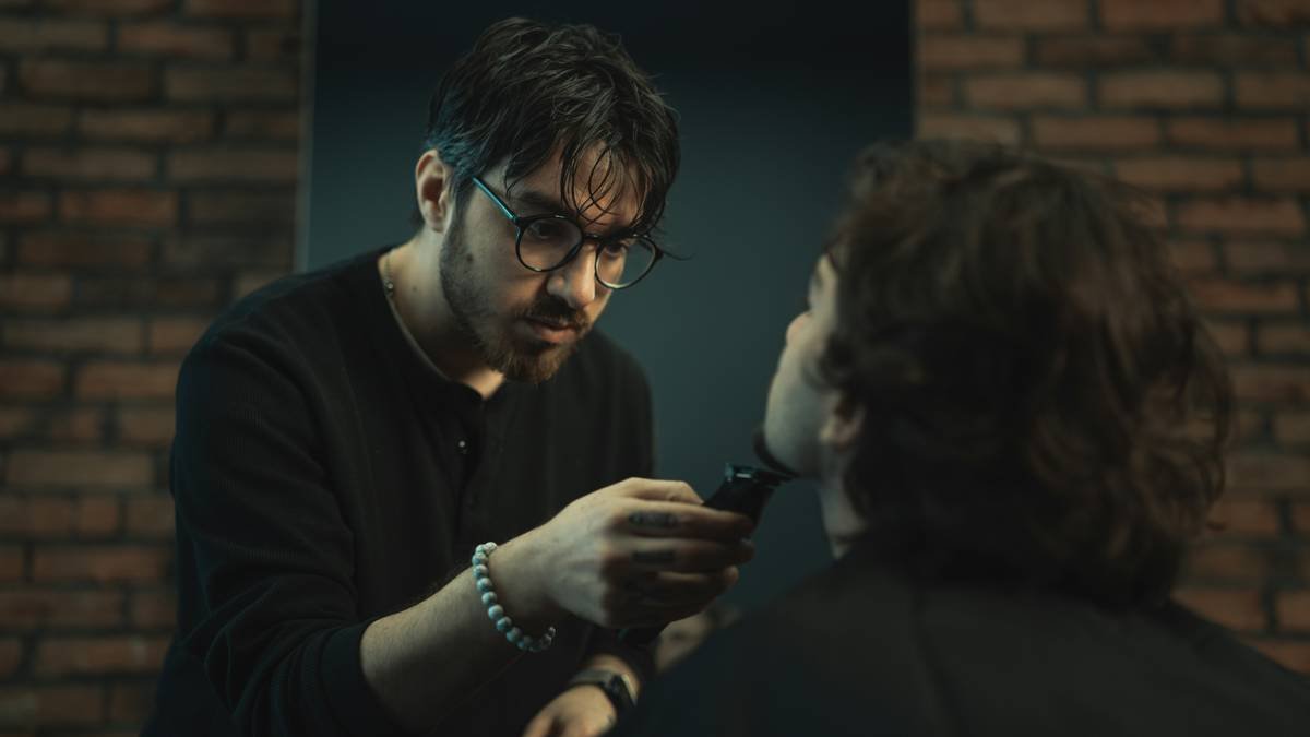 Man using a lightweight styling brush on his beard with natural lighting